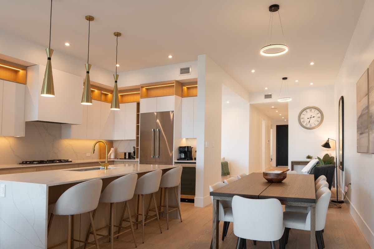Open-plan kitchen and dining room with pendant lights and white oak floors