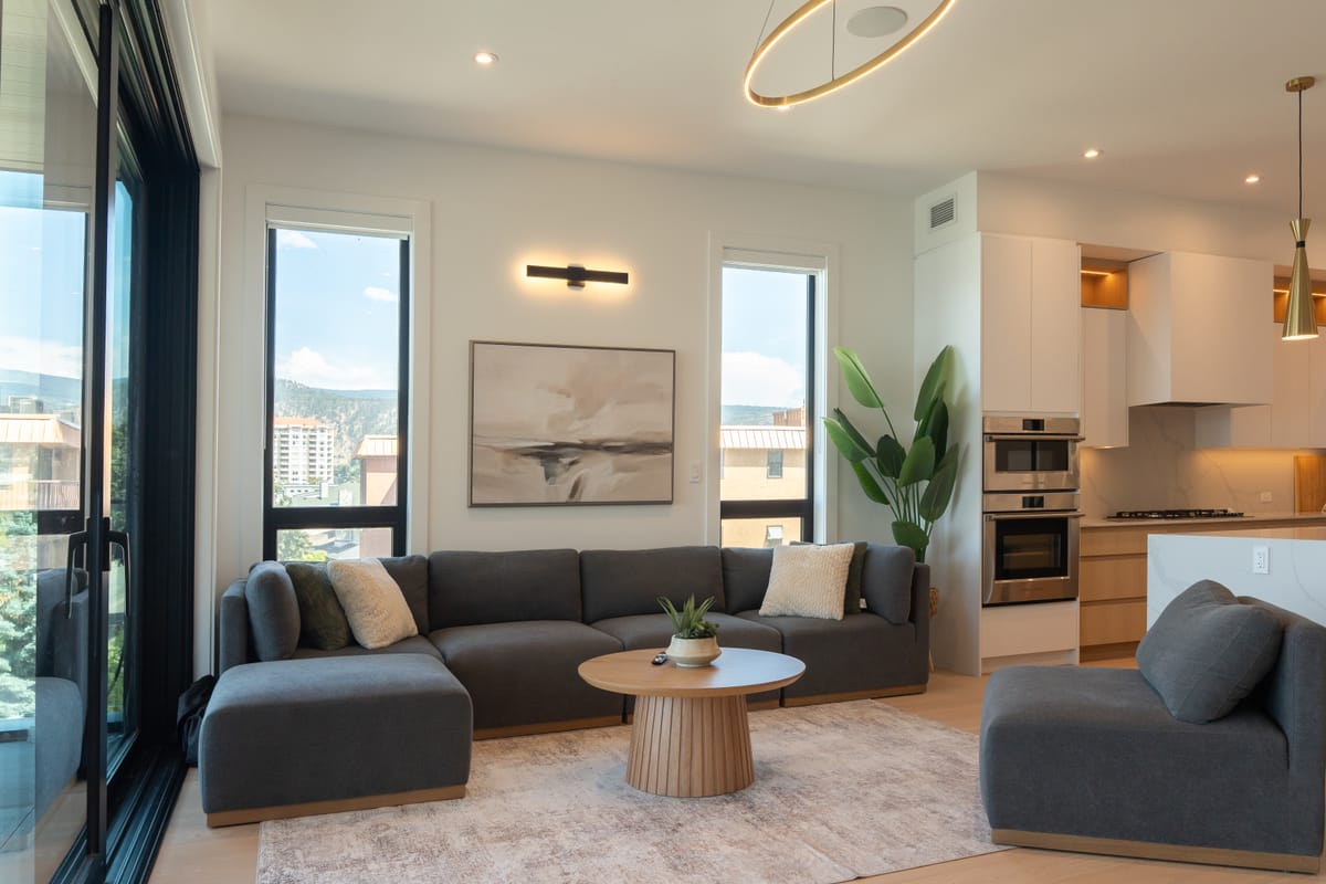 Living room with a grey sectional and the lake through the glazing