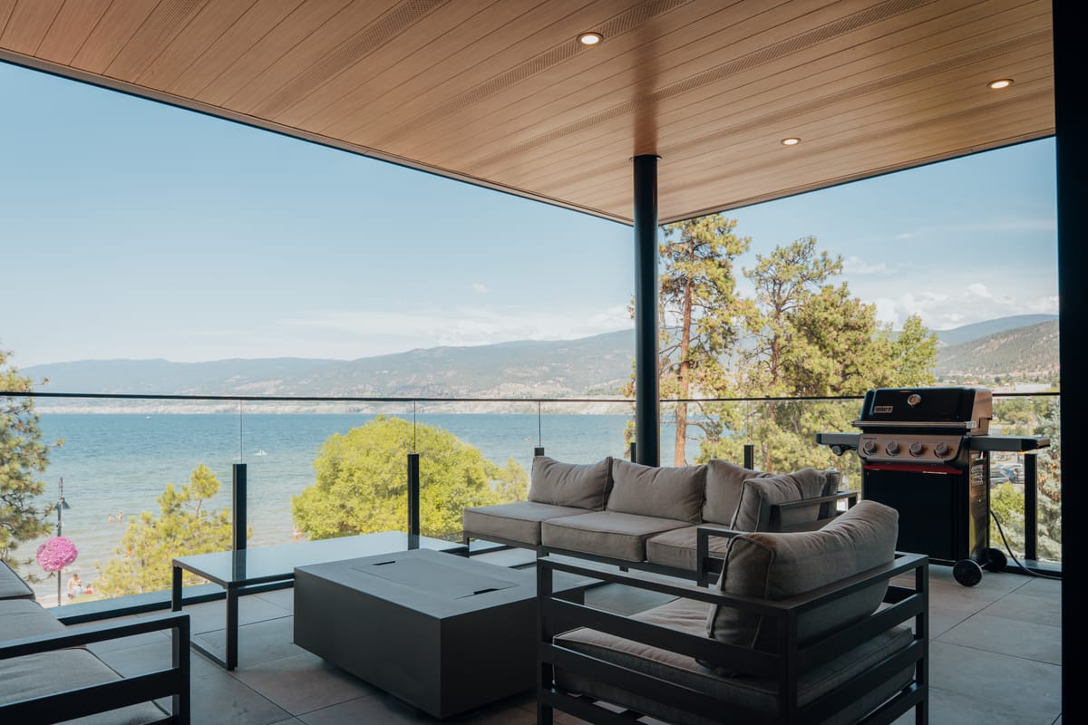 Covered patio with a cedar ceiling and lounge seating overlooking the lake